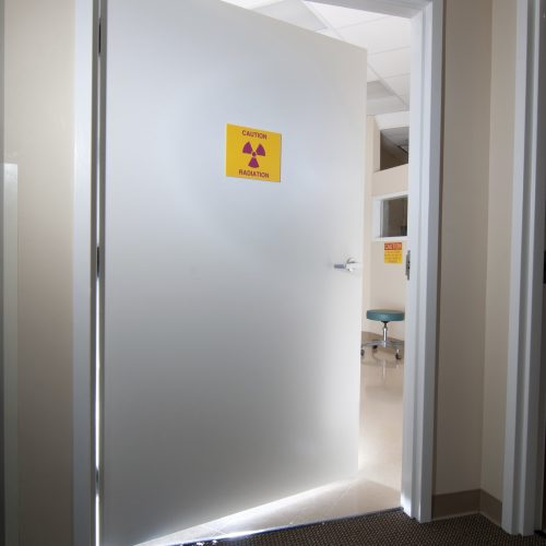 Door slightly ajar, with a radiation sign. Neutron/gamma shielding door